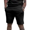 Detailed view of men's solid black athletic shorts featuring a vertical front seam. - S / Bottoms / Black