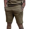 Detail view of men's olive green athletic shorts with seam design on fit model - Brown