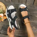 Detailweergave van zwarte platform sandalen voor dames met contraststiksels en klittenband. - Zwart