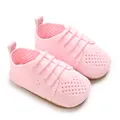 Close-up macro view of the pink hollow knit pattern on these baby princess flat shoes - Pink