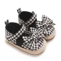 Nahaufnahme von Gingham-Sandalen für Babymädchen mit einer großen dekorativen Schleife - Schwarz