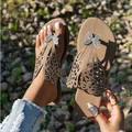 Primer plano de los detalles de mariposa y pedrería en sandalias playeras planas. - 36 / Gris