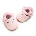 Dettaglio di scarpine da neonato a forma di coniglietto rosa con viso ricamato e morbide - Lunghezza Interna 12cm / Rosa