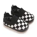 Primer plano de zapatos de punto para bebé a cuadros blancos y negros con suela blanda - Negro