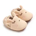 Primo piano di adorabili pantofole da neonato a forma di coniglio beige con righe - Albicocca