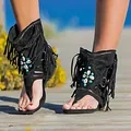 Detalle de sandalias boho negras con flecos, cuentas turquesas y adornos de conchas - Negro