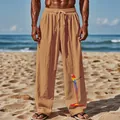 Gros plan du motif perroquet sur ce pantalon de plage pour homme en coton et lin respirant - Jaune Terre