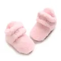 Nahaufnahme von weichen rosa Korallenvlies-Babyschuhen mit dicker, warmer Plüschtextur - Rosa