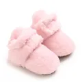Nahaufnahme von weichen rosa Korallenvlies-Babyschuhen mit flauschiger Textur und Design - Rosa