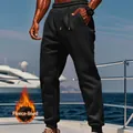 A detailed close-up of men's black fleece-lined joggers worn on a luxury yacht deck setting - Black