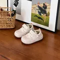 Gros plan de baskets rose et blanc pour tout-petits avec bandes velcro sur une table - Rose