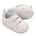 Detailed close-up view of white baby sneakers featuring pink heart embroidery and non-slip sole - White and Pink Heart