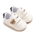 Primer plano de zapatos blancos para bebé con bordado de osito en la tira de velcro - Blanco Negro