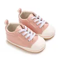 Close-up van roze PU-leren babyschoenen met zachte antislip rubberen zolen - Roze