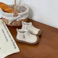Soft-sole beige baby Martin boots displayed in a cozy rustic lifestyle setting - Beige