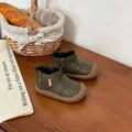 Detailed view of olive green toddler boots with soft rubber soles on a wooden table - Green