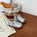 Children's silver metallic leather Martin boots with soft rubber soles in lifestyle setting - Silver