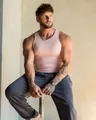 Vue détaillée d'un débardeur de sport rose ajusté sur un mannequin masculin musclé - M / Hauts / Rose