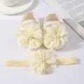 Gros plan détaillé de l'ensemble chaussures et bandeau bébé avec fleurs crème - Beige