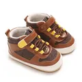 Detail view of brown and yellow baby boy soft sole casual walking shoes on white backdrop - Brown