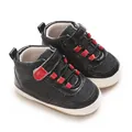 Detailed close-up of baby boy's soft sole black walking shoes with vibrant red accents. - Black