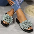 Dettaglio di sandali da donna con grandi decorazioni floreali verde salvia su suole nere - Verde