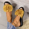Vista dettagliata di ciabatte piatte da donna con grandi fiori gialli decorativi. - Giallo