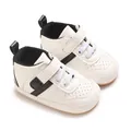 Close-up detail of white baby walking shoes with black stripes and soft non-slip soles - White Black
