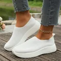 White fly-knit breathable mesh flat sneakers for women in a stylish lifestyle setting - 36 / White