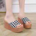 Zoom sur les sandales compensées pour femmes avec motif pied-de-poule et semelle tressée. - Noir
