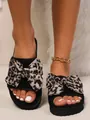Primo piano di ciabatte piatte nere da donna con un grande ed elegante fiocco leopardato - Farfalla Cachi