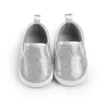 Nahaufnahme von glänzenden silbernen Glitzer-Lauflernschuhen für Babys mit weichen Sohlen - Silber