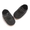 Vista ravvicinata di scarpe da ginnastica per neonati in pelle PU nera con fori traspiranti - Nero