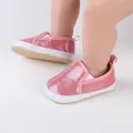 Close-up detail of pink glitter infant shoes featuring soft white soles on a baby's feet - Insole Length 11cm / Pink
