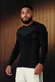 Detailed view of men's slim-fit black athletic long-sleeve shirt with patterned chest. - M / Tops / Black