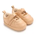 Dettaglio macro di scarpine primi passi beige con velcro e suola morbida per neonati. - Albicocca