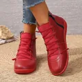 Detailed view of red women's high-top Martin boots on a woven straw mat background. - 36 / Red