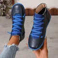 Close-up of navy blue high-top boots with vibrant blue laces and durable flat soles - Blue