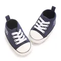 Vue détaillée des chaussures bébé bleu marine avec broderie ours et lacets blancs - Bleu
