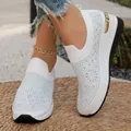 Detailaufnahme der glitzernden Strasssteine auf dem weißen Strickstoff der Sneaker - Weiß
