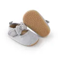 Nahaufnahme grauer Baby-Prinzessinnenschuhe mit einer rutschfesten Noppensohle - Grau