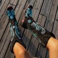 Detailed view of black suede knight boots featuring intricate blue floral embroidery - 36 / Black