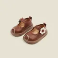 Detailed macro view of brown leather toddler shoes with a cute cream flower buckle design. - Internal Length 11.5cm / Brown