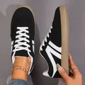 Retro black and white women's skate shoes with flat gum soles and white lace-up detail. - Black
