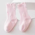 Detailed view of pink ripped distressed mid-tube kids socks with ruffled frayed cuffs - Pink
