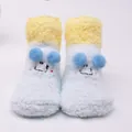 Close-up of cute light blue plush baby socks featuring a cartoon face and non-slip floor grip - 0-1 Years / Eye-Blue