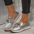 Detaillierte Nahaufnahme silberner Metallic-Loafer mit goldener Kette und Gummisohle - Silber