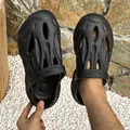 Detail of black unisex outdoor clogs with a unique mesh texture on white pebbles. - 38 / Black