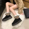 Close-up of black mid-calf snow boots with geometric patterned trim on a white rug. - 36 / Black