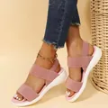 Detail van roze sandalen met elastische banden en dikke witte zolen aan een voet - Roze
